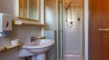 Badezimmer mit Duschkabine und Haartrockner