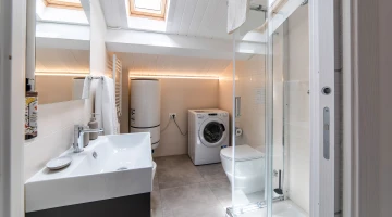 Badezimmer mit Dusche und Waschmaschine