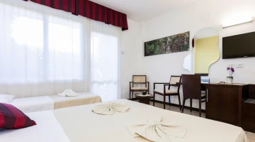 Dreibettzimmer mit TV und Schreibtisch