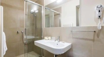 Salle de bain privative avec cabine de douche et sèche-cheveux mural