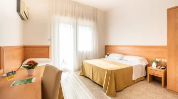    Dreibettzimmer mit Schreibtisch und eigenem Balkon