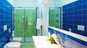 Eigenes Badezimmer mit wandmontiertem Haartrockner und Duschkabine