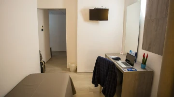 Einzelzimmer mit TV und Schreibtisch