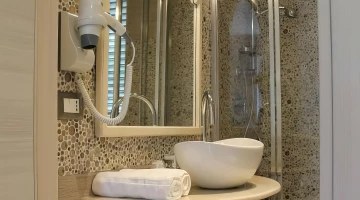 Salle de bain privative avec cabine de douche et sèche-cheveux mural