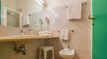 Private bathroom with wall-mounted hairdryer and shower cubicle