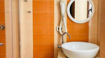 Private bathroom with shower cubicle and wall-mounted hairdryer