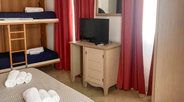 Quadruple room with bunk beds and TV