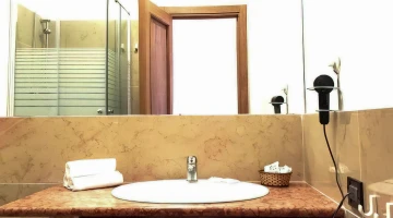 Bathroom with shower cubicle and wall-mounted hairdryer