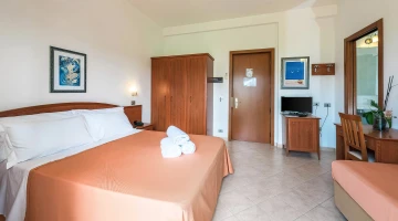Room with double bed and set of towels