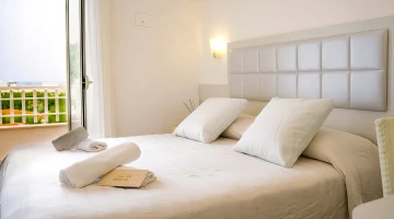 Room with double bed and set of towels