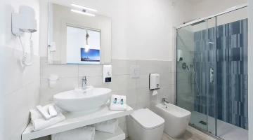 Private bathroom with shower cubicle and wall-mounted hairdryer
