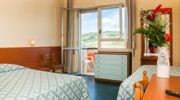Chambre triple avec balcon donnant sur la colline