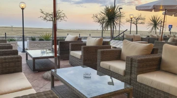Coin salon sur la terrasse avec vue sur la plage