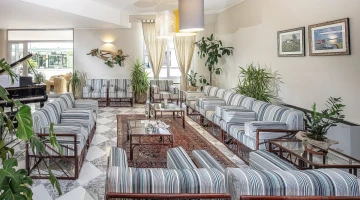 Sala comune con divani e pianoforte