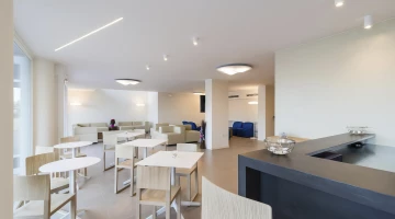 Aufenthaltsraum mit TV, Sofas, Tischen und Stühlen