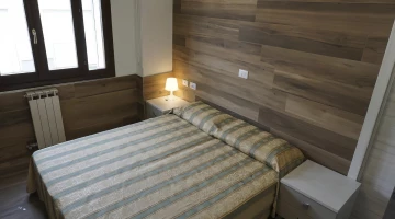Room with double wooden bed