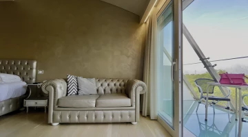 Suite con divano e balcone privato