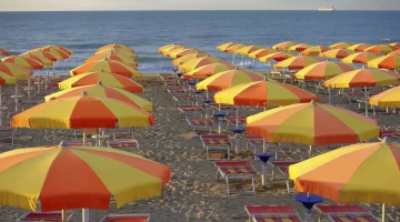 Strand mit Liegen und Sonnenschirmen ausgestattet