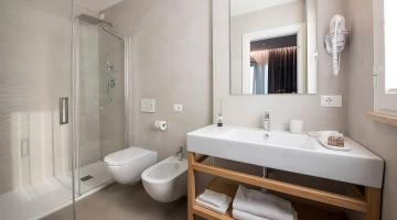 Salle de bain avec sèche-cheveux mural et cabine de douche