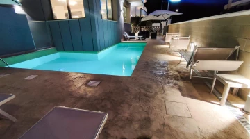 Swimmingpool umgeben von Sonnenliegen