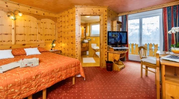 Room with double bed, TV and balcony