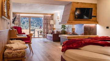Suite con camino e balcone arredato