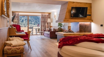 Suite con camino e balcone arredato