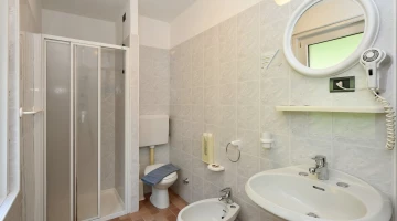 Badezimmer mit Duschkabine und Haartrockner