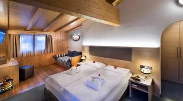 Doppelbett im Zimmer mit sichtbaren Balken