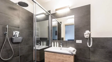 Salle de bain avec douche et sèche-cheveux mural