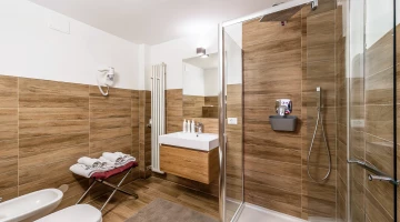 Salle de bain privative avec cabine de douche et sèche-cheveux mural