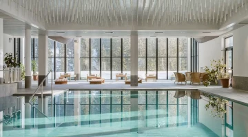 Panoramic swimming pool surrounded by glass windows