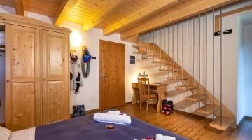 Familienzimmer mit Treppe und freiliegenden Balken