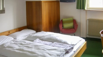 Zimmer mit Sessel und Kleiderschrank