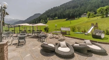 Outdoor terrace with tables and armchairs