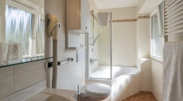Bathroom with wall-mounted hairdryer and bathtub