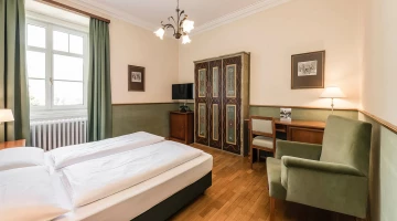 Zimmer mit Sessel und Schreibtisch