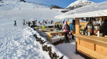 Overlooking the ski slope with bar and outdoor tables