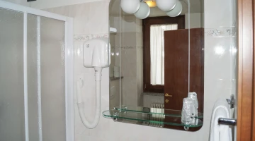 Private bathroom with shower box and wall-mounted hairdryer