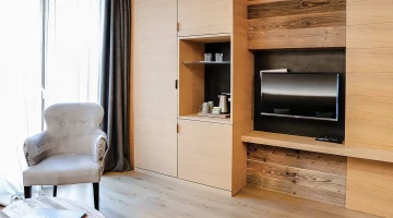 Zona giorno con TV e poltrona in una suite