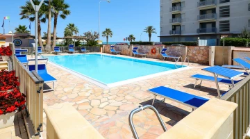 Chaises longues au bord de la piscine