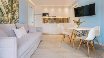 Salle à manger avec canapé et TV dans la villa