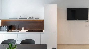 Fernseher und ausgestattete Küche in der Wohnung