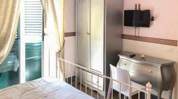 Zimmer mit Balkon und Fernseher