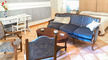 Zimmer mit Wohnbereich und Schreibtisch