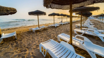 Lettini ed ombrello in spiaggia privata