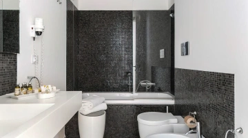 Bagno con vasca doccia e phon a parete