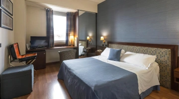 Camera matrimoniale con TV e finestra