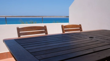 Tisch auf dem Balkon einer Wohnung mit Meerblick