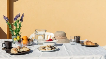 Der Tisch ist auf der Terrasse für das Frühstück gedeckt.